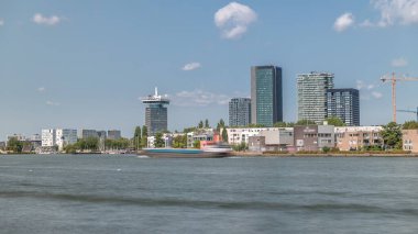 Amsterdam 'ın en modaya uygun modern kulelerinin zaman çizelgesi. Şehir merkezinde Hey seti üzerinde, Göz Film Müzesi' nin yanında. Mavi gökyüzünün altında bir feribot nehri geçer. Hollanda