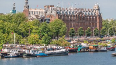 Amsterdam ufuk çizgisi Oosterdok limanındaki teknelerle Scheepvaarthuis hava zaman çizelgesi. Amsterdam Centraal İstasyonu yakınlarındaki geleneksel Hollanda mimarisi. Amsterdam, Hollanda