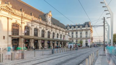 Fransa 'nın Aquitaine kentindeki ana demiryolu merkezi olan Bordeaux Saint Jean Tren İstasyonu, saatli büyük bir girişe sahiptir. Günbatımında tramvaylar geçer, tarihi cephede gölgeler hareket eder.