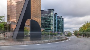 Brüksel Kuzey İstasyonu yakınlarındaki bir kavşakta bir çeşmenin zamanı. Simon Bolivar ve Roi Albert II caddelerinin kesiştiği yerde modern cam gökdelenlerle çevrili trafik akıntıları var. Belçika