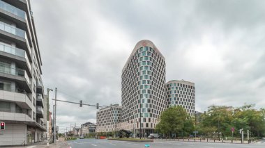 Baudouin Bulvarı, Brüksel, Belçika 'daki iş bölgesi zaman çizelgesinde trafik ve modern ofis binalarını gösteren panorama. Kavşağın yanındaki çağdaş kuleler bulutlu bir gökyüzünün altına park ederler.