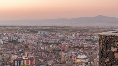 Nevsehir 'in tarihi şehir kentindeki eski şatonun hava görüntüsü. Günbekten geceye geçiş zamanı. Gün batımından sonra aydınlatılmış binalar ve yollar ile panoramik gökyüzü