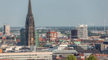 Aerial timelapse of Hamburg's historic city center skyline with bell tower of the Church of St. Nicholas and ancient harbor district viewed from bunker viewpoint. Port and wind power stations, Germany clipart