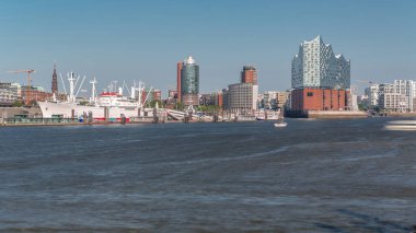 Hamburg 'un ikonik Elbphilharmonie konser salonunun ön planda tarihi bir kargo gemisiyle zaman dilimi. Arka planda Uberseebrucke ve Niederhafen, Hafencity rıhtımında. Almanya