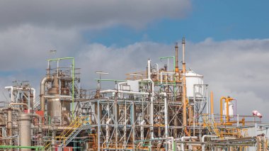 Damıtma Sütunları ve hidrojen bitkisinin zaman ölçümü ekipmanları. Arka planda bulutlar var. Bir çok boru ve tank gökyüzüne karşı endüstriyel fabrika