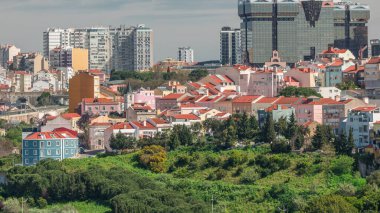 Amoreiras alışveriş merkezi kuleleriyle Lizbon 'un gökyüzü manzarası. Campo de Ourique semti yakınlarındaki tarihi binalarda Monsanto 'nun bakış açısından yeşil ağaçların zamanı geçiyor. Lizbon, Portekiz