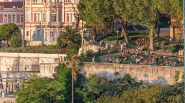 Geleneksel bir bahçe ve Lizbon şehir merkezine akşam boyunca alışılmadık manzaralı Jardim do Torel zaman çizelgesi. İnsanlar terasta gün batımını seyrediyor. Portekiz