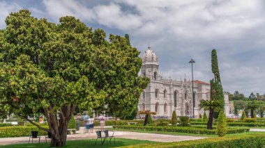 Mosteiro dos Jeronimos ve bahçede çimenliği olan yeşil ağaçlar, Lizbon, Portekiz 'in Belem bölgesinin zaman diliminde yer almaktadır. Manueline tarzı (Portekizce geç Gotik). Mavi gökyüzünde bulutlar