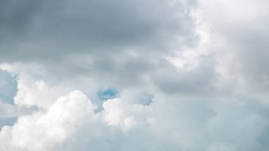 Close up view of some cumulus clouds during stormy weather timelapse. Blue sky background with white clouds. Massive cumulus cloud in the summer sky before rain clipart