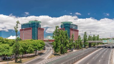 Centro Colombo 'nun ve Lizbon' daki modern ofis binalarının uçuş hızları. Otoyolda trafik vardı ve bulutlar mavi gökyüzünde hareket ediyordu. Şehir merkezindeki ünlü alışveriş merkezi. Portekiz