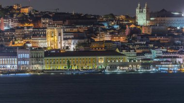Lizbon 'un aydınlık tarihi merkezi Terreiro do Paco ve Tagus Nehri' nin alacakaranlıktaki hava zaman çizelgesinde tarihi binalar, feribot terminali ve Portekiz 'deki Se de Lisboa Katedrali yer alıyor.