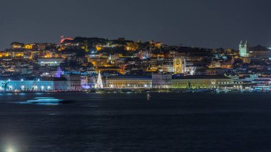 Lizbon Ticaret Meydanı 'nın zaman çizelgesi Noel için aydınlatıldı. Turistler, açılış ışık gösterisi sırasında parlayan ağacın ve dekorasyonların etrafında toplanıyorlar. Portekiz 'in başkentinde gece sahnesi