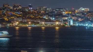 Lizbon 'un aydınlık Amoreiras kuleleri, Santos bölgesi, tarihi rıhtımlar ve Portekiz' in güney kıyısında Almada 'dan seyredilen Tagus Nehri' nin gökyüzü çizgisi.