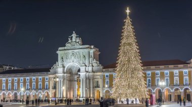 Lizbon 'daki ticaret meydanı, Noel' de yüksek bir ağaç ve geceleri kemerle aydınlandı. Dekorasyon ve tarihi mimarinin yer aldığı şenlikli atmosferin zamanlaması