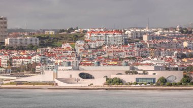 Portekiz 'in Lizbon kentindeki Tagus Nehri' ne tepeden bakan Champalimaud Vakfı 'nın amfitiyatrosu ve deniz kıyısının havadan çekilmiş zaman çizelgesi. Kırmızı çatılı evlerle çevrili modern bir biyomedikal araştırma merkezi..