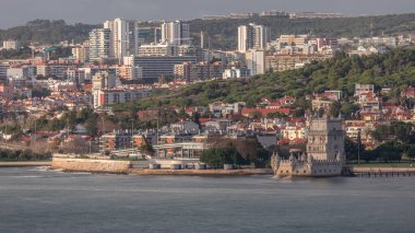 Lizbon, Portekiz 'deki Belem Kulesi' nin hava zaman çizelgesi, Tagus Nehri 'nin tarihi simgesi. Akşamları deniz manzarası, insanlar arka planda bir inşaat alanından vincin etrafında geziniyor.