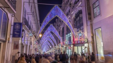 Lizbon şehir merkezindeki Chiado Carmo sokağındaki Noel ışıkları ve dekorasyonları gece aşırı hızlandı. İnsanlar aydınlanmış kemerlerin altında yürürler. Portekiz 'de festival dekorlu tatil atmosferi