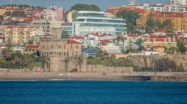 Forte de Cruz zaman dilimi, 17. yüzyıldan kalma Tamariz Sahili 'ndeki bir kale, şimdi bir etkinlik mekanı. Atlantik kıyısında siperleri olan tarihi bir şato. Arka planda modern binalar. Estoril, Portekiz