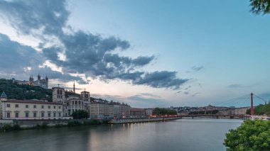 Aziz John 'un Vaftizci Katedrali ve Lyon' daki Notre-Dame de Fourviere Bazilikası 'nın zaman çizelgesi, günden geceye değişiyor. Yansıtılmış rıhtım ve nehirde yansıyan binalar. Fransa