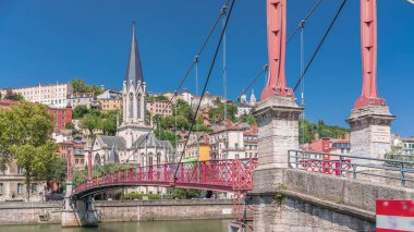 Aziz George Kilisesi, Quais de Saone ve Fourviere Bazilikası 'nın Fransa' nın Vieux Lyon kentindeki bir yaya köprüsünden hızlandırılmış zamanaşımı, tarihi mimari, yansımalar ve manzaralı nehir manzarası sergileniyor.