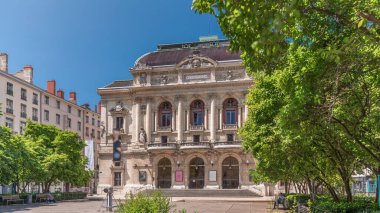Fransa 'nın Lyon şehrinde Celestins Tiyatrosu' nun zamanaşımı. Place des Celestins 'te tarihi bir tiyatro. Ağaçlar, banklar ve mavi gökyüzünün altında dinlenen insanlar. Klasik mimari ve kültürel cazibe