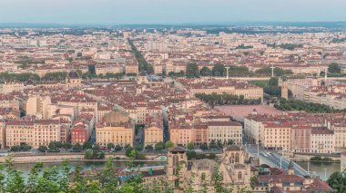 Gün batımında Fourviere Hill 'den Lyon' un panoramik hava görüntüsü. Ufuk çizgisinde Bellecour, Rhone Nehri ve sıcak akşam ışığında aydınlanan ikonik şehir simgeleri yer alıyor.
