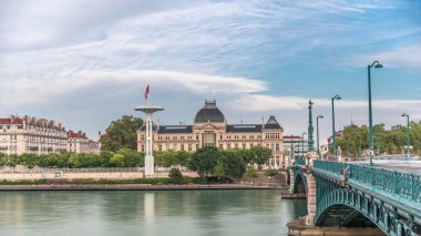 Fransa 'nın Lyon kentindeki Jean-Moulin Üniversitesi' nin yer aldığı Rhone Nehri 'nin panoramik hiperhızlandırılmış manzarası ve seti. Parçalı bulutlu bir gökyüzü zaman diliminin altında Üniversite Köprüsü ve rıhtımını içerir