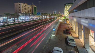 Suudi Arabistan, Riyad 'daki Kral Fahd Yolu' nun gece panoramik zaman çizelgesi. Günümüz kuleleri ve gökdelenleri ile çevrili Riyad Ulusal Kütüphanesi 'nin yakınındaki araçlarla yoğun bir trafik vardı.