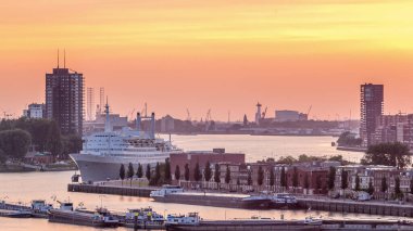 Aerial timelapse of Maashaven harbour during sunset in Rotterdam, The Netherlands. Features the waterfront skyline and the SS Rotterdam, a former cruise ship now a hotel, moored at Katendrecht clipart