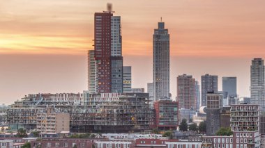 Aerial day to night transition timelapse of Katendrecht peninsula and Maashaven harbour in Rotterdam, The Netherlands. City skyline modern skyscrapers and traditional Dutch waterfront houses clipart