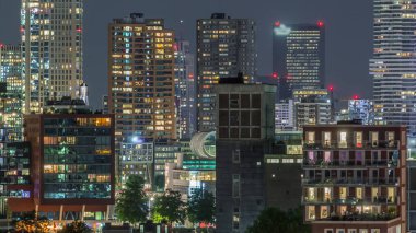 Rotterdam şehir merkezi, Hollanda 'daki modern binaların uçuş zamanı. Finans bölgesinde aydınlık kuleler ve gökdelenler. Parlayan pencereler, parlak bir gece silueti oluşturuyor.