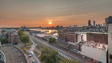 Gün batımında Maashaven zamanının hava panoramik görüntüsü Rotterdam 'da demirli iç gemilerle, Katendrecht ve Maas Nehri. Eski fabrika ofis ve etkinlik alanına dönüştü. Yollar boyunca trafik