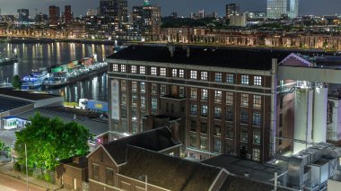 Eski fabrikanın hava panoramik görüntüsü ofise dönüştürüldü ve uzay gecesi zaman aşımına uğradı. Maashaven 'da demirlemiş gemileri olan kuleler, Katendrecht ve Maas Nehri, Rotterdam. Yol trafiği