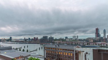 Rotterdam 'daki Katendrecht ve Maas Nehri' nin dramatik gökyüzü, Maashaven 'ın gündüz ve gece arası panoramik görüntüsü. Eski fabrika yakınlarındaki trafik ofis ve etkinlik alanına dönüştü