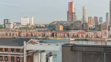 Rotterdam, Hollanda 'daki Katendrecht Yarımadası ve Maashaven Limanı' nın panoramik zaman çizelgesi. Sabah şehir silueti, modern gökdelenler ve Hollanda kıyısı evleri olan eski fabrikalar.