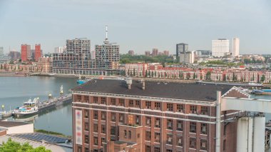 Rotterdam 'daki Maashaven' da, iç kısımlara demirlemiş gemiler, Katendrecht ve Maas Nehri 'nin üzerindeki hava zaman ayarlı görüntüsü. Eski fabrika ofis ve etkinlik alanına dönüştü. Hollanda