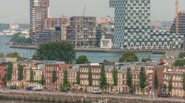 Rotterdam, Hollanda 'daki Katendrecht Yarımadası ve Maashaven Limanı' nın panoramik zaman çizelgesi. Şehir sabahları gökdelenler, vinçler ve geleneksel Hollanda rıhtım evleri.