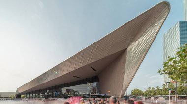 Rotterdam Merkez İstasyonu 'nun hiperlapesi, Hollanda, Güney Hollanda' daki ana demiryolu merkezi. Arka planında gökdelenler olan modern mimari ve kare zaman diliminde meşgul insanlar