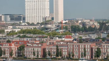 Rotterdam, Hollanda 'daki Katendrecht Yarımadası ve Maashaven Limanı' nın panoramik zaman çizelgesi. Şehir sabahları ufuk çizgisi, modern kuleler, inşaat alanı ve geleneksel sahil evleri