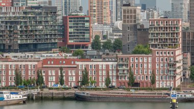 Rotterdam şehir merkezi, Hollanda 'daki modern binaların uçuş zamanı. Finans bölgesindeki kuleler ve gökdelenler sabah sıcacık ışıklarıyla canlı bir ufuk çizgisi oluşturuyor. Rıhtımdaki gemiler