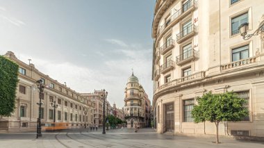 Avda boyunca yürüyen yayalar. De la Constitucion, Seville, İspanya 'nın Casco Antiguo bölgesindeki ana cadde. Edificio de la Adriatica ile zaman atlaması, tarihi binalar ve geçen tramvaylar