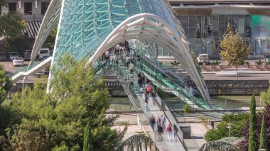 Rike Park 'ı Gürcistan' ın başkenti Tiflis 'e bağlayan, Kura Nehri üzerinde yay şeklinde bir çelik ve cam köprü olan Barış Köprüsü' ne giriş zamanı.