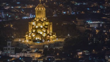 Aydınlatılmış Tsminda Sameba Katedrali ya da Tiflis hava gece zaman çizelgesi Kutsal Üçlü Katedrali. Gürcistan 'ın Tiflis kentindeki Gürcistan Ortodoks Kilisesi' nin ana katedrali. Arka plandaki evler
