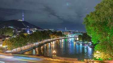 Gece vakti Barış Köprüsü ve rıhtımı aydınlatması, Kura Nehri üzerindeki yay şeklindeki çelik ve camdan köprü, Rike Park 'ı Tiflis, Georgia' daki Eski Şehir 'e bağlıyor.