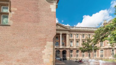 Rönesans zindanı ve Capitole arka tarafındaki klasik tuğla cephesi zaman atlaması, Fransa 'nın Toulouse belediyesi, Charles de Gaulle Meydanı' nda bulutlu bir gökyüzünün altında ağaçlarla çevrili.