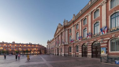 Capitole de Toulouse 'da gece gündüz geçiş zamanı hiperhızlandırılmış şehir merkezi ve Fransa' nın tarihi merkezi Toulouse, Capitole Meydanı 'nda akşam üstü gökyüzü altında sergilenmektedir.