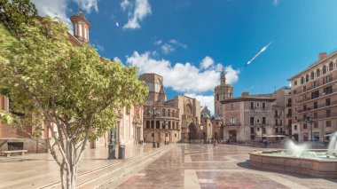 Valencia Plaza de la Virgen 'in panoramik zaman atlaması, İspanya' nın tarihi bulutlu gökyüzü altında Turia Fountain, Cathedral ve Basilica de la Virgen de los Desamparados sergileniyor.