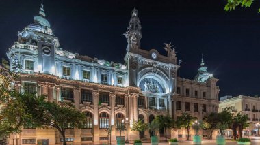 Historic Post Office (Palau de les Comunicacions) in Valencia night timelapse hyperlapse at City Hall Square (Plaza del Ayuntamiento). Ornate facade and street traffic in the Spanish city center. clipart