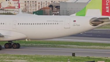 Lizbon Humberto Delgado Havaalanı 'nda arka planda tepeler ve şehir manzarası olan çeşitli uçaklar hareket halindedir. Uçak taksisi, kalkış ve iniş Portekiz 'de güneşli bir günde.