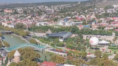 Yukarıdan Rike Park 'a. Tiflis 'in eski bir kasabasındaki modern şehir parkı. Şehirdeki dinlenme bölgesinde yeşil ağaçlar ve çimenler. Huzur Köprüsü ve konser salonu. Georgia